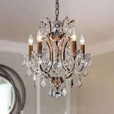 a crystal chandelier hanging from a ceiling in a room with white walls and windows