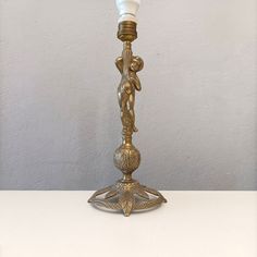 an ornate brass candle holder with a white light on top