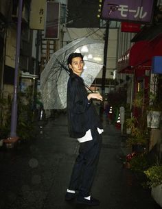 a man standing on the street holding an umbrella