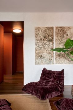 a living room with two paintings on the wall and a bean bag chair in front