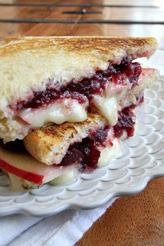 a white plate topped with a cut in half sandwich on top of a wooden table