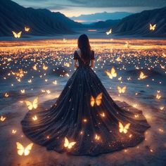 a woman is standing in the middle of a field with butterflies flying around her and looking at the sky