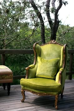 a green chair sitting on top of a wooden deck