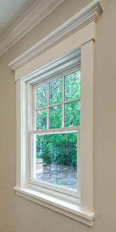 an empty room with a large window in the corner and no curtains on the windowsill