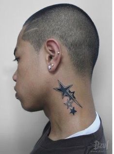 a man with a star tattoo on his neck and behind his ear is looking to the side