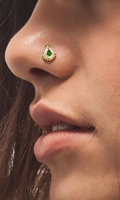 a close up of a woman's nose with a gold nose ring on it