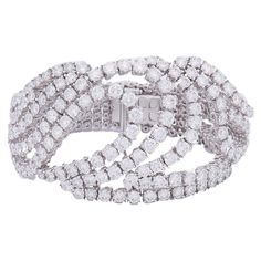 An exquisite Boucheron bracelet made of 18 karat white gold and diamond. This spectacular bracelet has a unique, outstanding design. It comprises of ten flexible gold and diamond strings running towards each other. The strings meet in the middle, creating a layered loop crafted as a stylized drop. This white gold and diamond bracelet is a fascinating piece, airy and substantially sparkly at the same time. The central element creates an amazing effect of the diamonds floating above the wrist. The Boucheron Bracelet, Bulgari Ring, Boucheron Jewelry, Gold And Diamond Bracelet, Modern Bracelets, Bracelets Gold Diamond, Local Jewelry, Expensive Jewelry, Antique Diamond