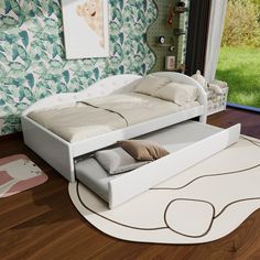 a white bed sitting on top of a hard wood floor next to a green wall