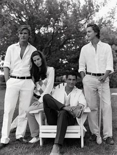 three men and two women are posing for a black and white photo in the grass