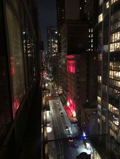 a city street at night with cars and buildings lit up in bright red, white and blue lights