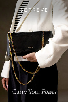 Woman in white blazer and black tailored pants holding a black leather clutch with two gold chains draping on the front. The Atlas, Stockings, Shades, The World, Leather, Clothes