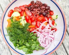 a white plate topped with lots of different types of veggies on top of a wooden table