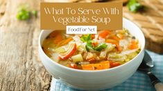 a white bowl filled with vegetable soup on top of a wooden table