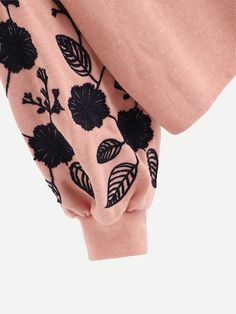 a pink sweater with black flowers on it