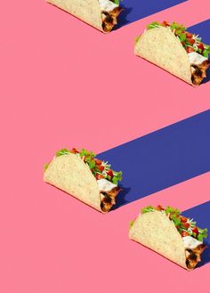 three tacos on pink and blue striped background