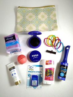 an assortment of personal care items laid out on a white surface with a zippered pouch