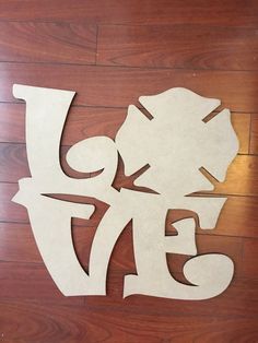 a cutout of the word love on a wooden floor next to a pair of scissors