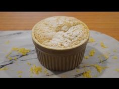 a muffin sitting on top of a marble plate covered in lemon zeurce