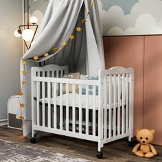 a baby's room with a crib, teddy bear and stars on the wall