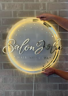 a person holding a neon sign with the word salon soap on it's side