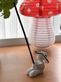 a lamp that is on top of a table next to a bird figurine