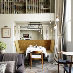 a living room filled with furniture and a dining table next to a window covered in curtains