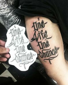 a person with a tattoo on their arm holding up a piece of paper that says live life the change