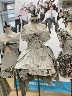 three mannequins made out of newspaper are on display