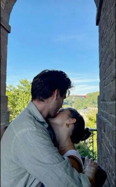 a man and woman kissing in an archway