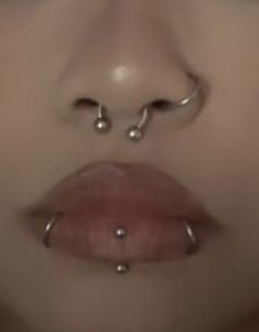 a woman's nose with piercings on it