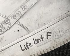 an old pair of shoes with the words life isn't fair written on them