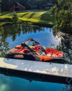 two boats are parked on the dock next to the water in front of a house