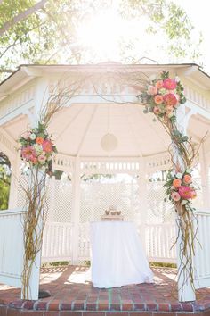 a white gazebo decorated with flowers and greenery