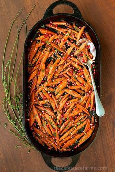 a pan filled with cooked carrots and garnished with pomegranate