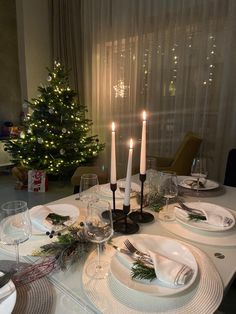 a table set for christmas with candles and plates