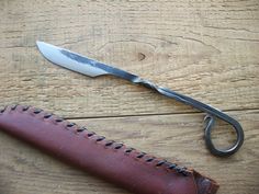 a knife and sheath sitting on top of a wooden table