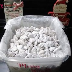 a large tub filled with lots of snowballs next to boxes of christmas cookies and candy