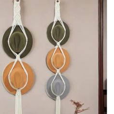 three plates are hanging on the wall with tassels attached to each plate,