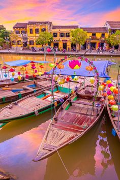 colorful boats are docked in the water near buildings