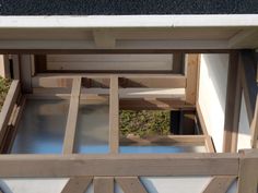 an open window in the side of a building with wood frame and glass panels on it