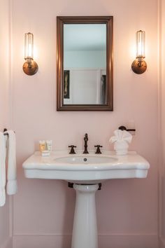 a white pedestal sink sitting under a mirror