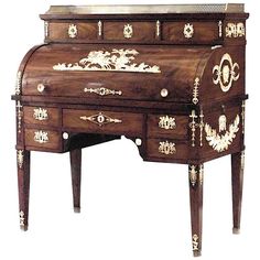 an ornately decorated wooden desk with gold trimmings and floral decorations on the drawers