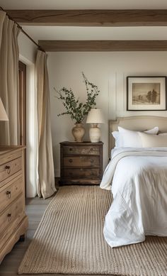 a bedroom with a bed, dressers and two lamps on either side of the bed