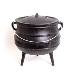 a cast iron pot sitting on top of a wooden stand