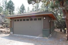 a garage in the middle of some trees and rocks with no one around it,