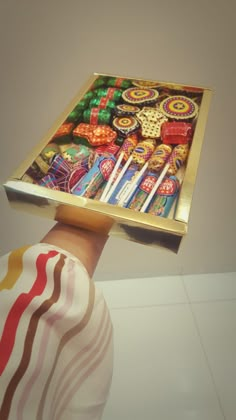 a person's hand holding a tray with candy on it