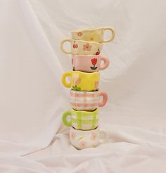 a stack of coffee cups sitting on top of each other in front of a white background