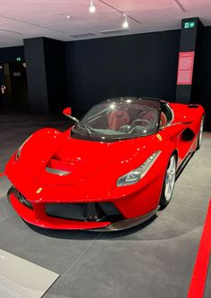 a red sports car on display in a building