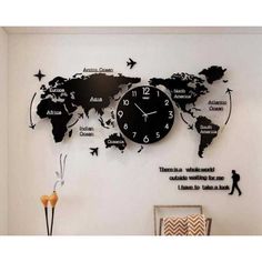 a clock mounted to the side of a wall with words on it and a world map