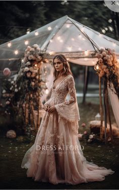 a woman standing in front of a gazebo wearing a wedding dress with long sleeves